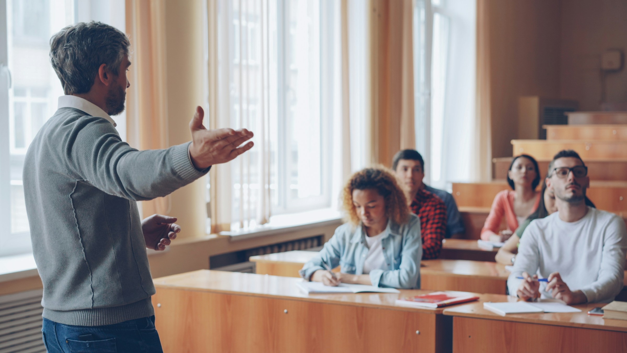 A professor lecturing students in a university lecture hall