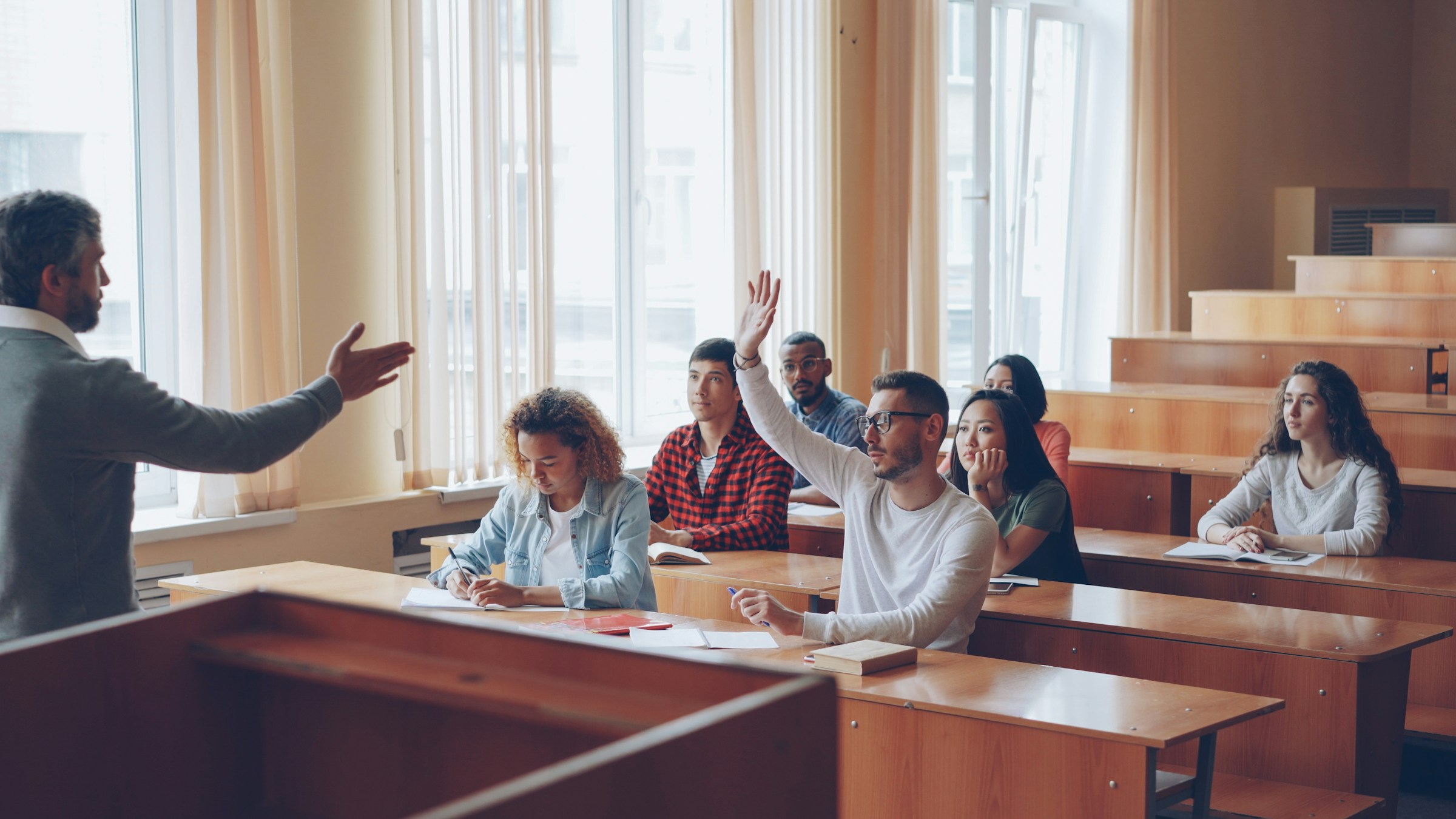 Students raising their hands in a classroom